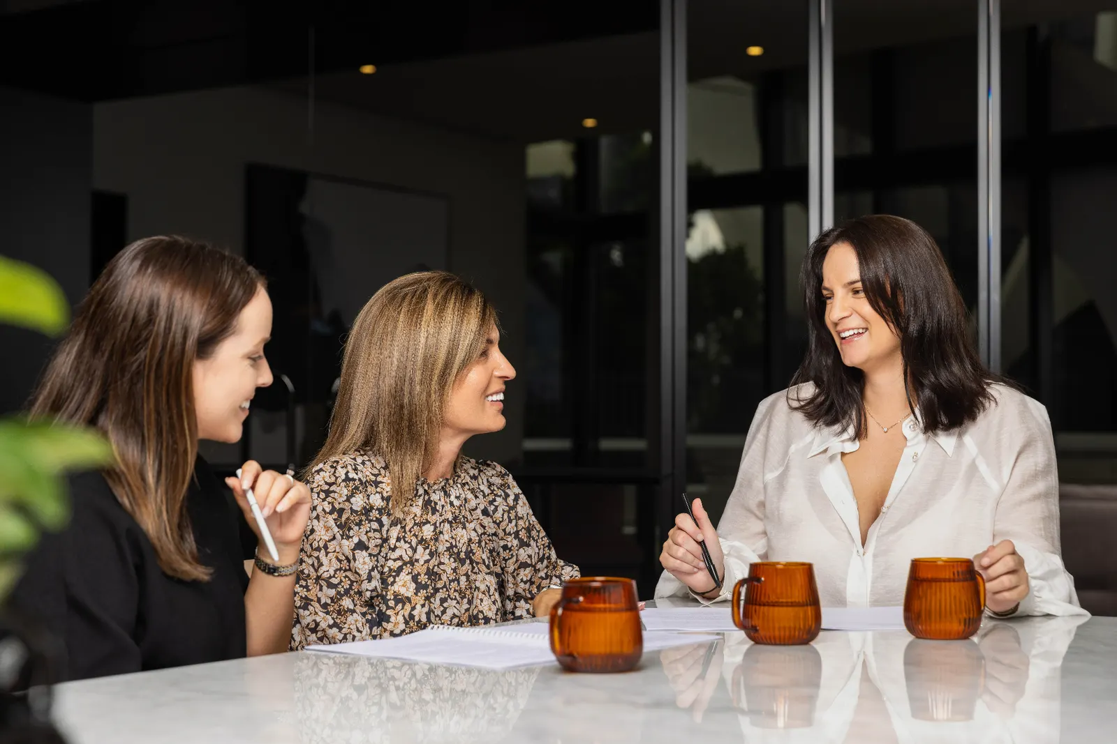 Three Wakefield Pacific team members in conversation around a meeting table